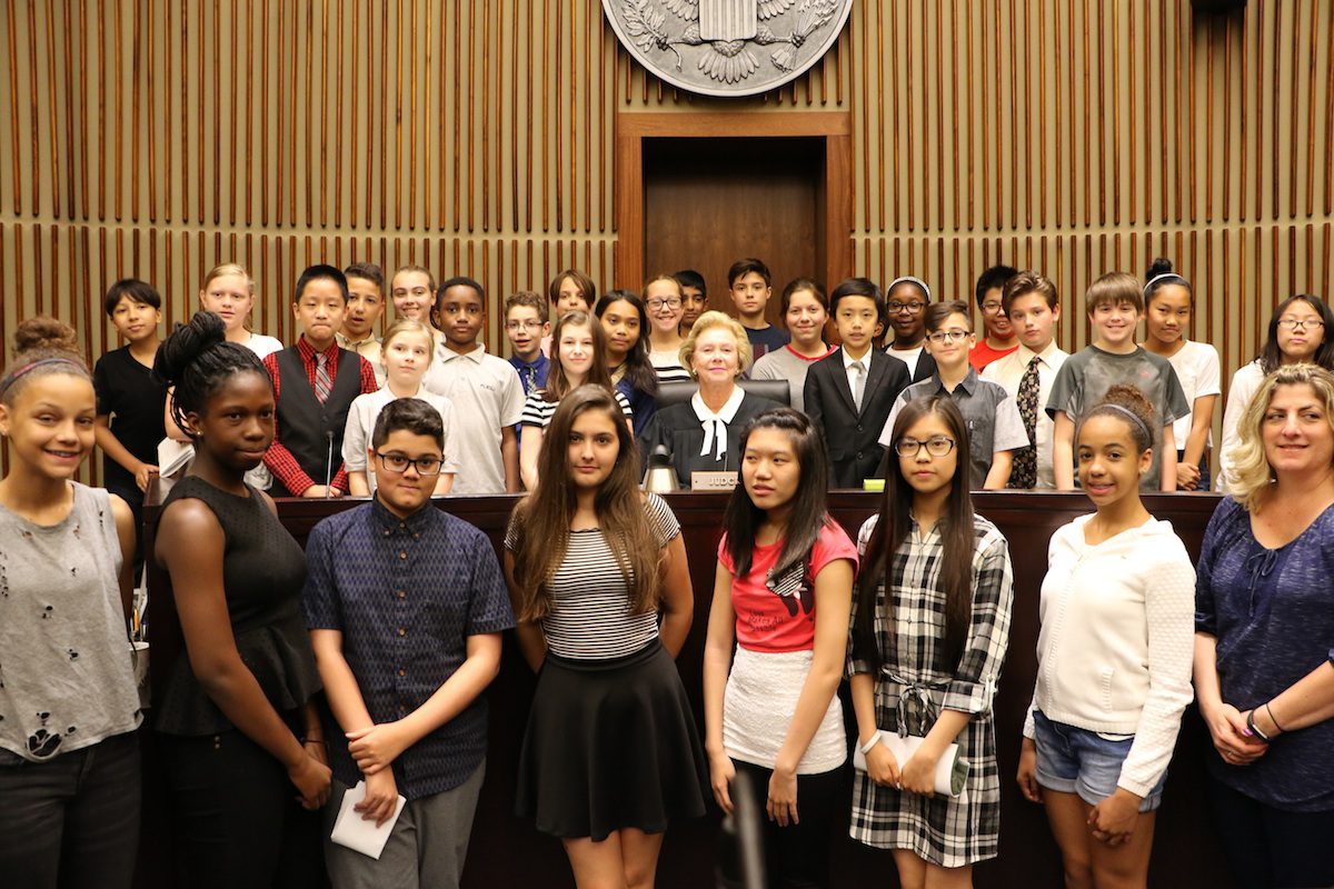 Judge Marjorie Rendell and local school students pose at the judge's bench in federal courtroom