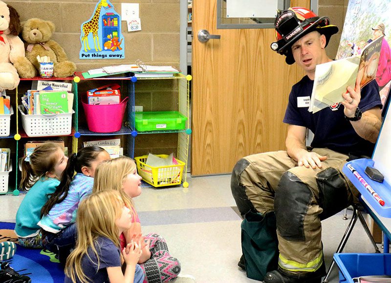 Fireman in classroom reading to kids