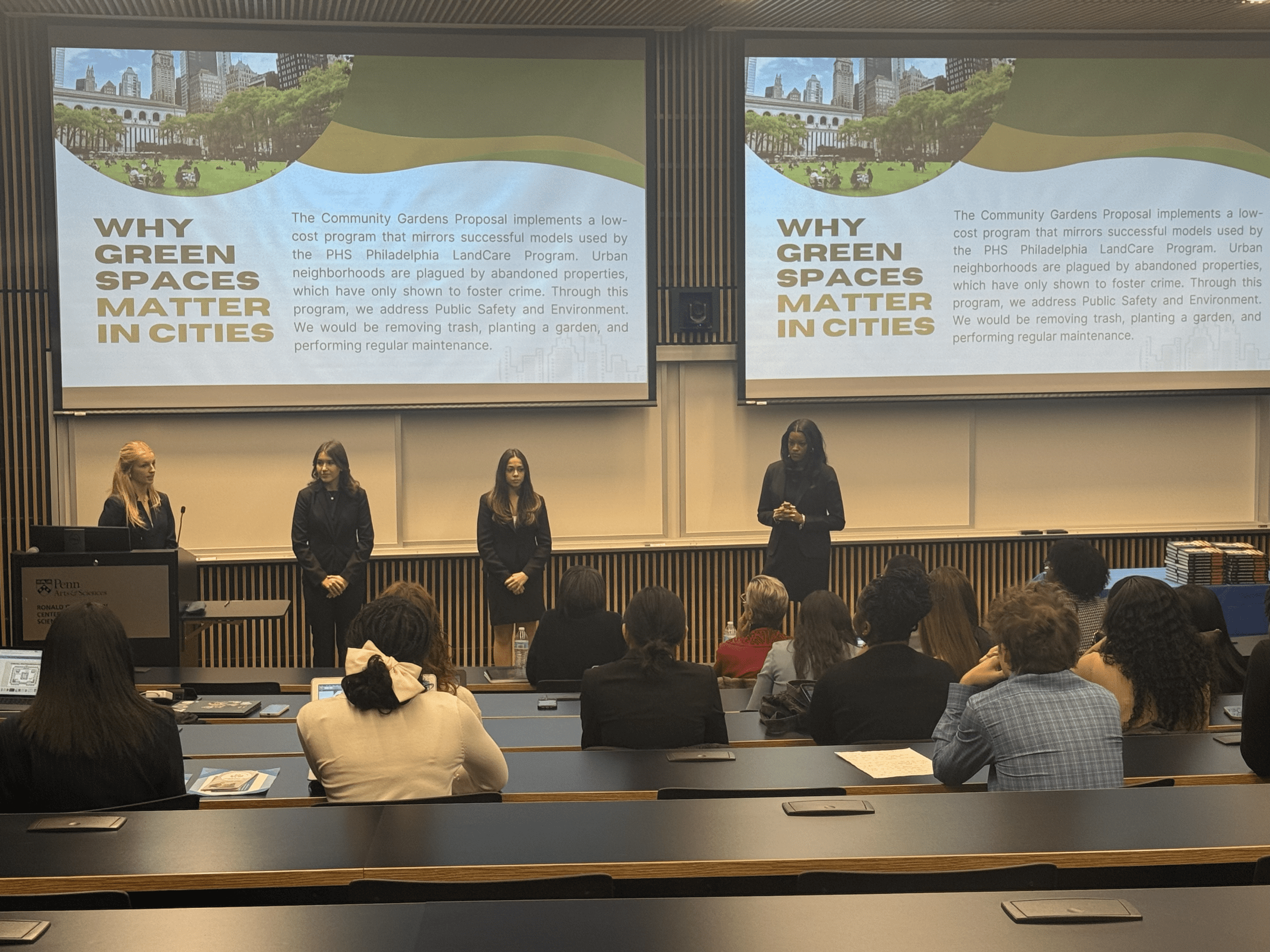 Students presenting in front of large presentations